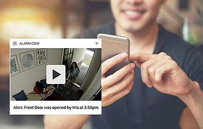 Homeowner checking security camera motion alerts and live footage on smartphone app